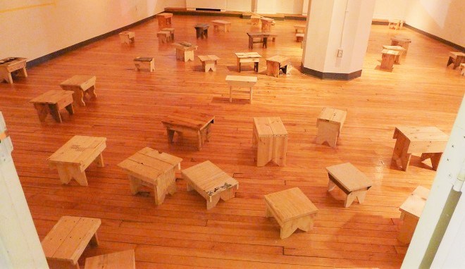 Wooden stools arranged during a rehearsal for Travelling Talismans